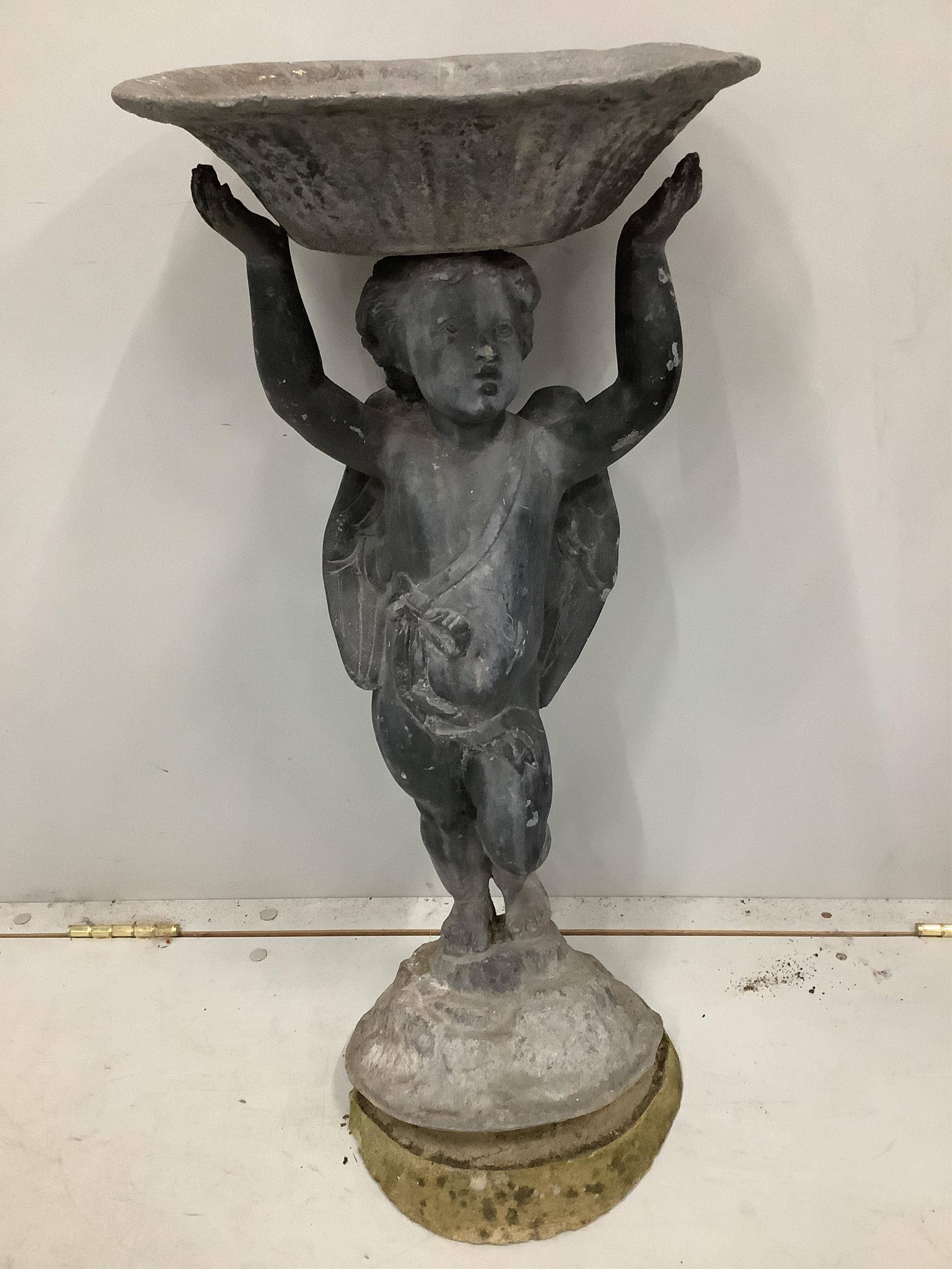 A lead bird bath with cupid stem, height 73cm. Condition - weathered with some old dents and scratches, base is levelled with cement but overall fair to good